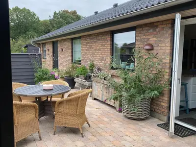 a patio with a table and chairs and a building at Hyggeligt hus. in Holstebro