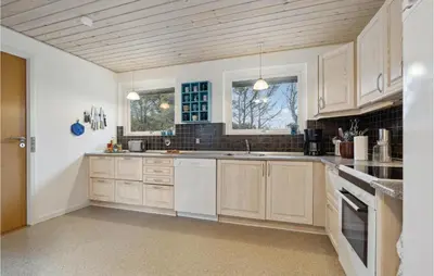 a kitchen with wooden cabinets and white appliances at 3 Bedroom Lovely Home In Vestervig in Vestervig