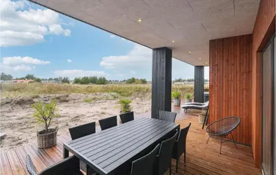 a dining room with a table and chairs on a deck at Awesome Home In Thisted With Sauna in Thisted