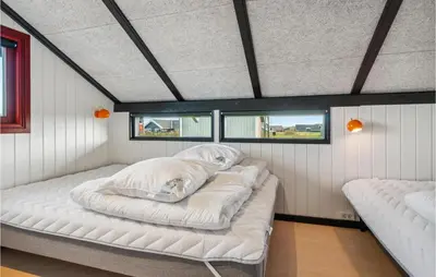 a large bed in a room with two windows at Nice Home In Harboøre With Wifi in Harboør