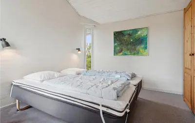 a bed in a bedroom with a painting on the wall at Pet Friendly Home In Thisted With Wifi in Thisted