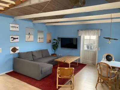 a living room with a couch and a table at Agger Beach Apartment in Vestervig