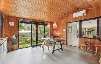 a kitchen and dining room with wooden walls and a table at 2 Bedroom Gorgeous Home In Højslev in Højslev