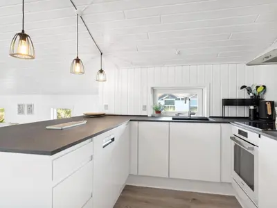 a kitchen with white cabinets and a counter top at Holiday Home Blaguna - 600m from the sea by Interhome in Torsted