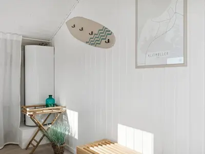 a living room with a table and a refrigerator at Holiday Home Blaguna - 600m from the sea by Interhome in Torsted