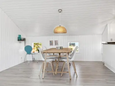 a dining room with a wooden table and chairs at Holiday Home Blaguna - 600m from the sea by Interhome in Torsted