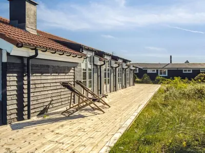 a wooden walkway next to a building with a building at Holiday Home Blaguna - 600m from the sea by Interhome in Torsted