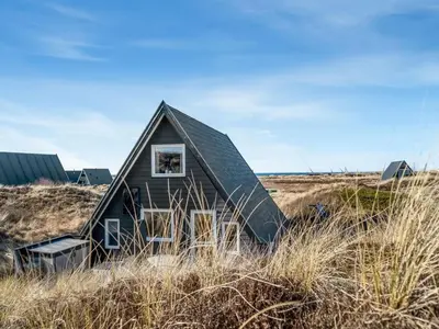 a small house in a field of tall grass at Holiday Home Pauli - 350m from the sea by Interhome in Pandrup