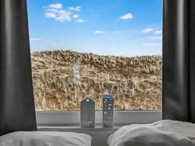 a bedroom with a view of a field through a window at Holiday Home Pauli - 350m from the sea by Interhome in Pandrup