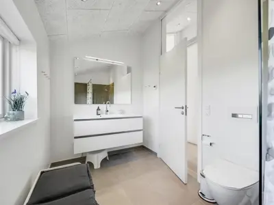 a white bathroom with a sink and a toilet at Holiday Home Gebko - 150m from the sea by Interhome in Saltum
