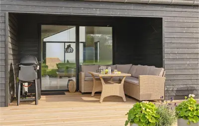 a patio with a couch and a table and a grill at Cozy Home In Lemvig With House Sea View in Lemvig