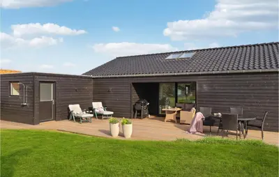 a backyard with a wooden deck with a grill at Cozy Home In Lemvig With House Sea View in Lemvig