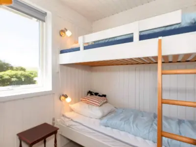 a bedroom with bunk beds and a table and a window at 6 person holiday home in Nykøbing M-By Traum in Alsted