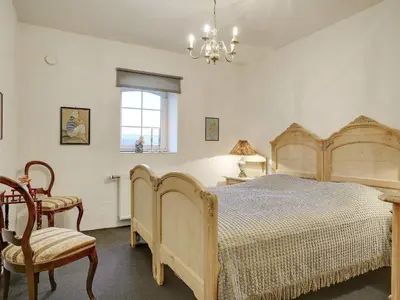 a bedroom with a bed and a chair and a chandelier at 5 star holiday home in Spøttrup-By Traum in Spottrup