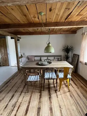 a dining room with a wooden table and chairs at The Beach Farm - charm, beach and stunning nature in Bedsted Thy