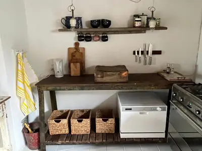 a kitchen with a table with baskets and a stove at The Beach Farm - charm, beach and stunning nature in Bedsted Thy