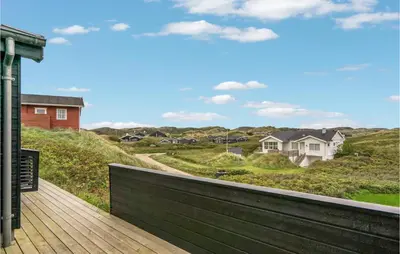 a wooden deck with a view of a house at Beautiful Home In Blokhus With Wifi in Blokhus