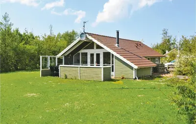 a small house with a green lawn in front of it at Nice Home In Vinderup With Kitchen in Vinderup