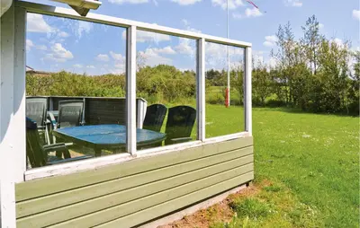 a screened in porch with a table and chairs at Nice Home In Vinderup With Kitchen in Vinderup