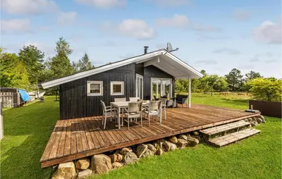 a black tiny house with a wooden deck at Holiday Home Højslev 42 in Højslev
