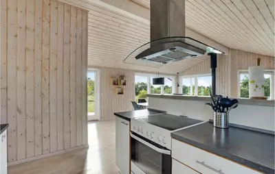 a kitchen with wooden walls and a stove top oven at Holiday Home Højslev 42 in Højslev