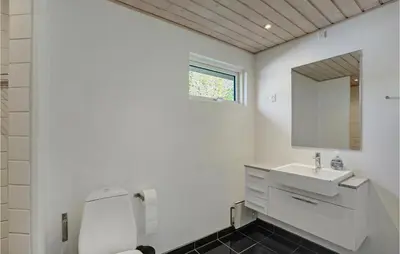 a white bathroom with a sink and a mirror at Holiday Home Højslev 42 in Højslev