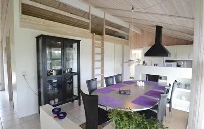 a dining room and kitchen with a table and chairs at Holiday Home Blokhus 49 in Blokhus