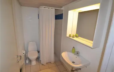 a bathroom with a sink and a toilet and a mirror at Holiday Home Blokhus 49 in Blokhus