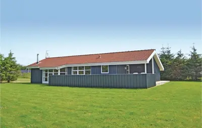 a house with a green lawn in front of it at Holiday Home Blokhus 49 in Blokhus
