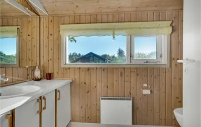 a bathroom with a sink and two windows at Holiday Home Blokhus 58 in Blokhus