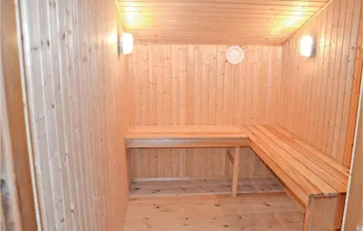 a wooden sauna with a wooden bench in it at Holiday Home Blokhus 58 in Blokhus