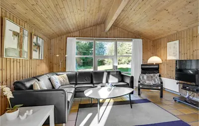 a living room with a couch and a table at Holiday Home Blokhus 58 in Blokhus
