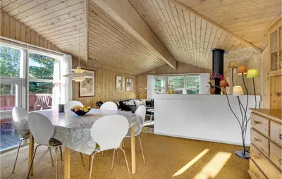 a kitchen and dining room with a table and chairs at Holiday Home Blokhus 58 in Blokhus