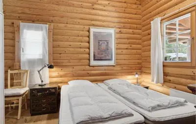 a bedroom with a bed in a wooden wall at Holiday Home Blokhus 59 in Blokhus