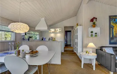 a kitchen and living room with a white table and chairs at Holiday Home Blokhus 9 in Blokhus