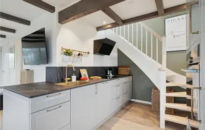 a kitchen with white cabinets and a staircase at 3 Bedroom Amazing Home In Højslev in Højslev