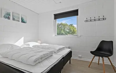 a white bedroom with a bed and a black chair at Amazing Home In Farsø With Wifi in Farsø