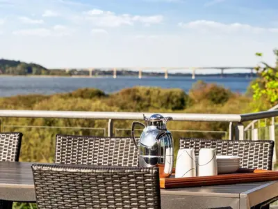 a table with chairs and a pitcher on top at Holiday Home Berta - 70m to the fjord by Interhome in Roslev