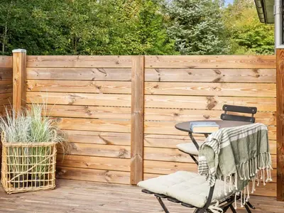 a wooden fence with a table and chairs on a deck at Holiday Home Jobst - 600m to the fjord by Interhome in Roslev