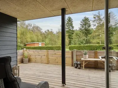 an outdoor deck with a table and a bench at Holiday Home Jobst - 600m to the fjord by Interhome in Roslev