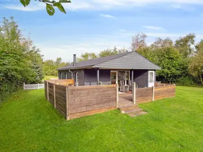 a house with a wooden deck in the grass at Holiday Home Jobst - 600m to the fjord by Interhome in Roslev