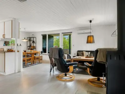 a kitchen and living room with a table and chairs at Holiday Home Jobst - 600m to the fjord by Interhome in Roslev