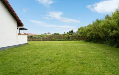 a large yard with a fence and a grass field at 3 Bedroom Pet Friendly Home In Ulfborg in Ulfborg