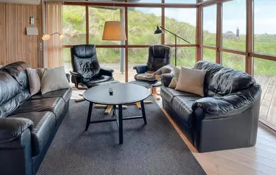 a living room with leather couches and a table and chairs at Beautiful Home In Saltum in Saltum