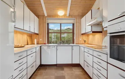 a kitchen with white cabinets and a window at Beautiful Home In Saltum in Saltum
