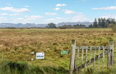 a fence in a field with a sign on it at 2 Bedroom Cozy Home In Fjerritslev in Fjerritslev