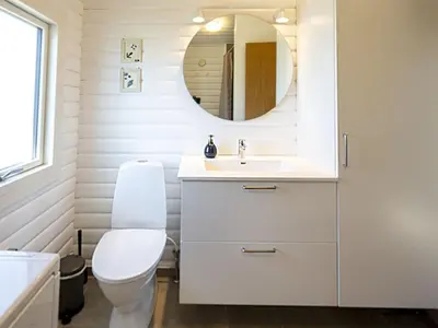 a bathroom with a white toilet and a mirror at Holiday Home Efra - 400m from the sea by Interhome in Saltum