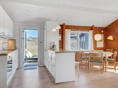 a kitchen and dining room with a table and chairs at Holiday Home Efra - 400m from the sea by Interhome in Saltum