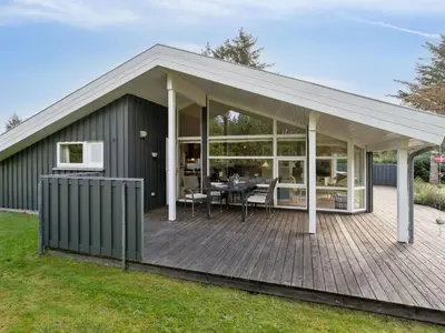 a large covered deck with a dining table on it at Holiday Home Sigbritt - 2-6km from the sea by Interhome in Blokhus