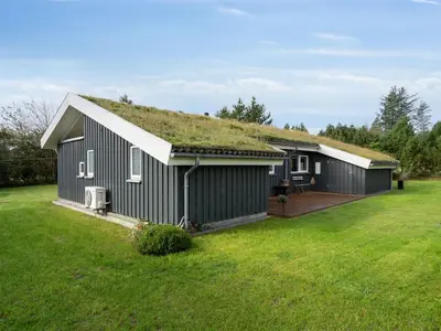 a house with a grass roof with a yard at Holiday Home Sigbritt - 2-6km from the sea by Interhome in Blokhus